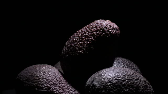 Mountain of ripe hass avocados fruit at black background